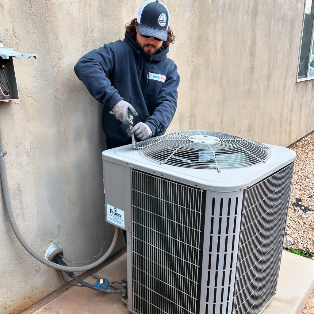 Desert Comfort Utah technician servicing HVAC condenser unit